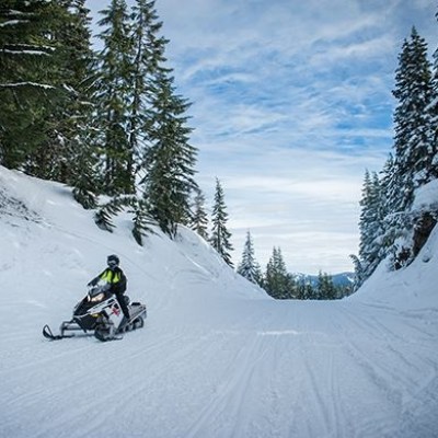 a man riding a snowboard down a snow covered slope