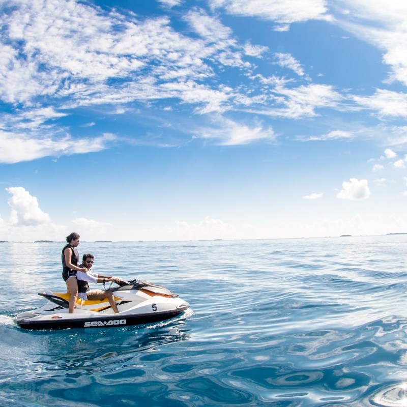 a man riding on the back of a boat in the water