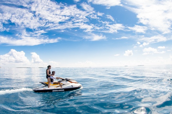 a man riding on the back of a boat in the water