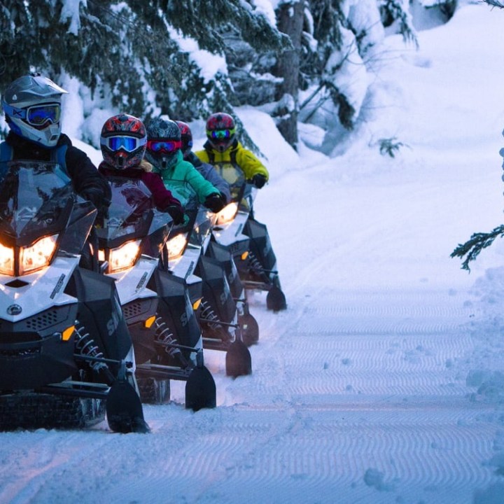 a man sitting on top of a snow covered slope